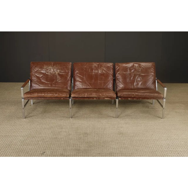 For those who love beautifully distressed leather, this three-seat sofa designed by Preben Fabricius and Jørgen Kastholm...