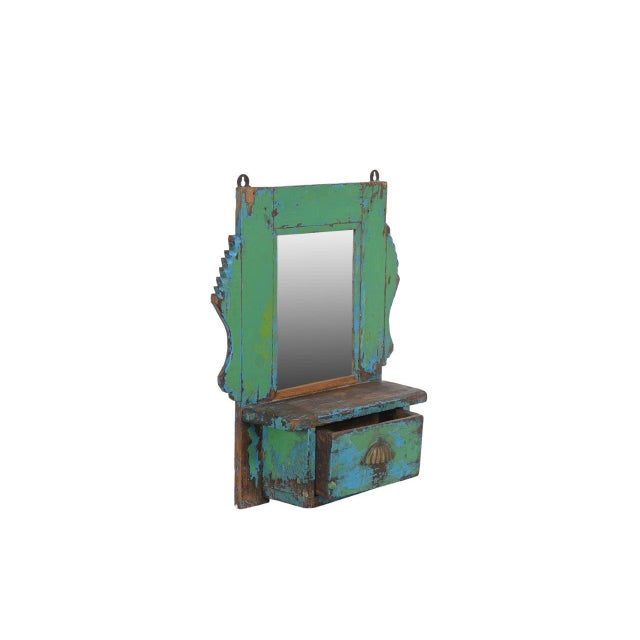 This Vintage Indian Hanging Wall Mirror is handcrafted from solid teakwood and finished in layers of weathered turquoise,...