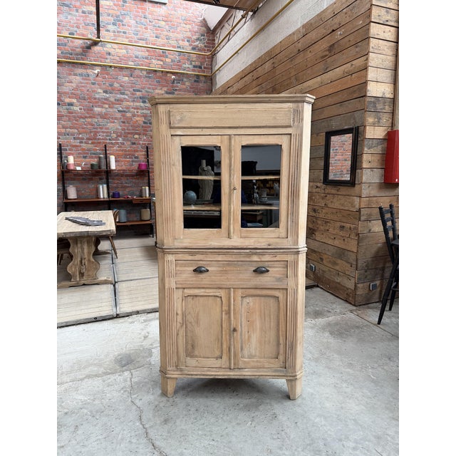 This rough-hewn elm corner cabinet, dating from the 1950s, has been fully restored. It consists of an upper section with...