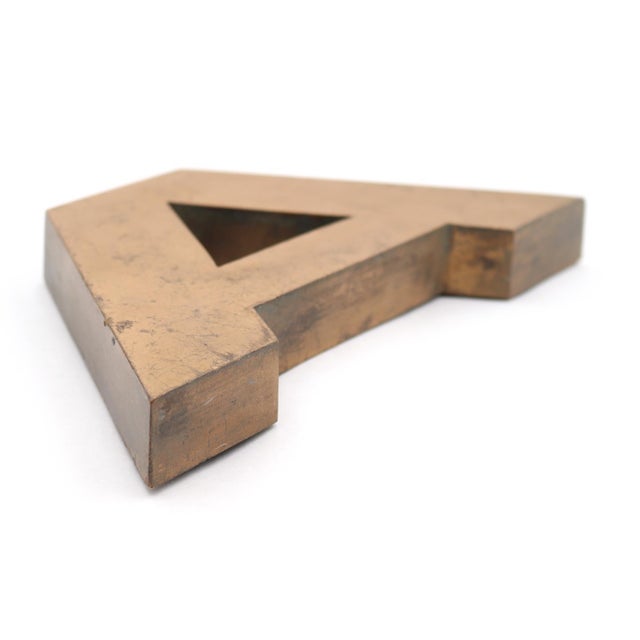 Vintage block style letter A made of brass with a brushed finish. The piece has a hollow back with three prongs. Good...