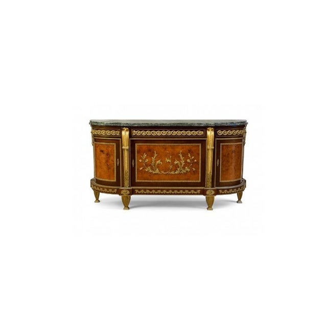 A Louis XVI style demi-lune commode of breakfront form. Three doors with figured burl panels framed in gilt-bronze...