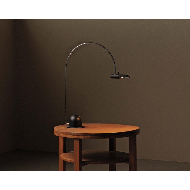 Elegant desk lamp in black lacquered metal, produced by Pierre Disderot in France around 1970–1980. It features a circular...