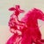 wide-brimmed hat rides a rearing horse, both rendered in hot pink against a dreamy pastel background of aqua, cream and...