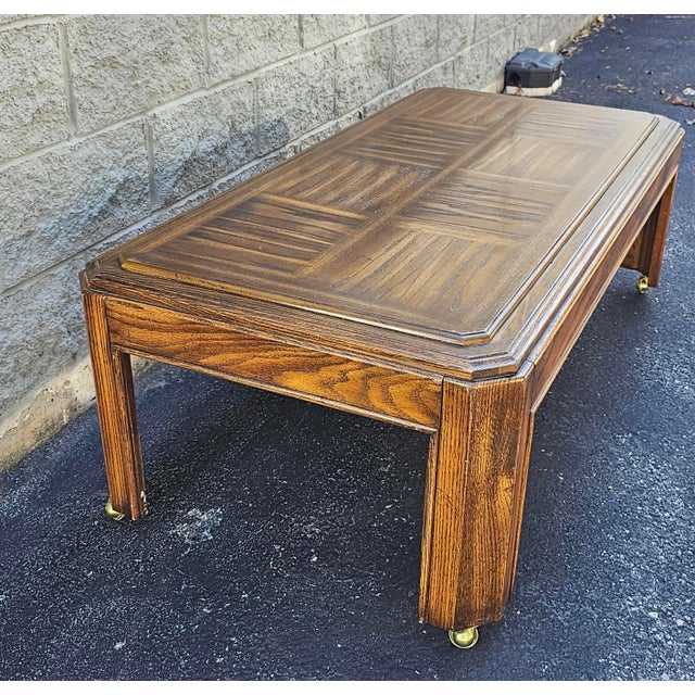 A late 20th Century Oak Parquet coffee table on casters in great vintage condition. Measures 52" in width, 26" in depth...