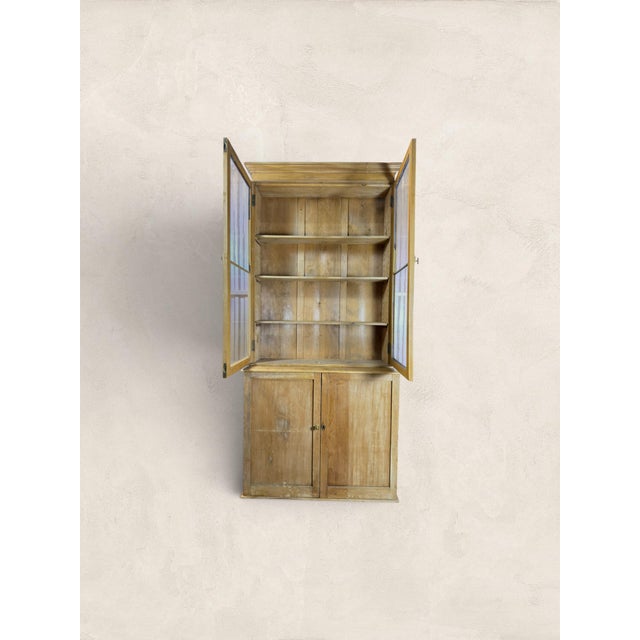 A glazed upper cabinet sitting above a paneled cupboard base. This Victorian pine bookcase is the kind of piece that earns...
