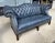 This Vintage Blue Leather Camelback Chesterfield Sofa features rich blue leather upholstery with deep button tufting...