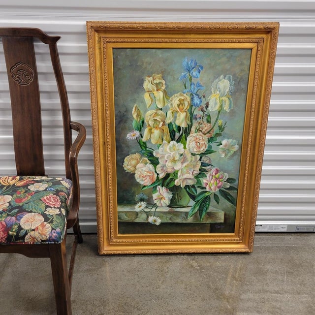 A decorative and serene painting of a floral arrangement featuring iris in a gold gilt wood frame. Signed by artist,...
