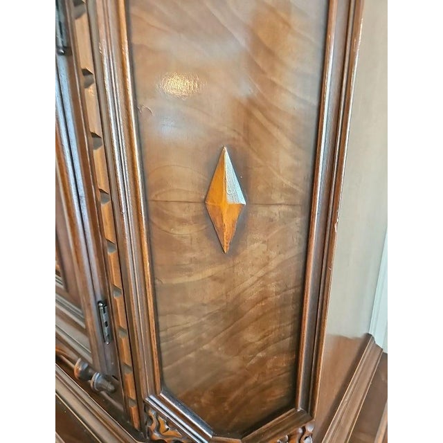 Renaissance Revival-style cabinet with a carved floral center panel, diamond inlay and an architectural two-part...