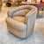 A beautiful tan taupe colored barrel chair with soft ruched detailing and a circular swivel mechanism on base for easy...