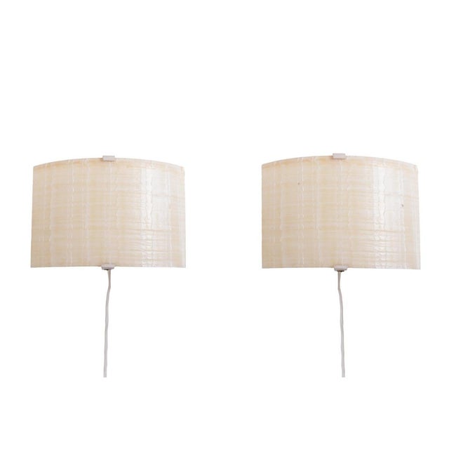 Minimalist, super modern wall sconces composed of a curved shade on a white lacquered metal frame. Designed and created in...