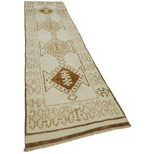 This exquisite runner rug is a rare example of tribal craftsmanship, hand-knotted by the women of the Herki tribe during...