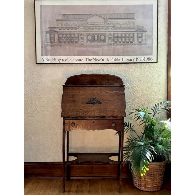 Antique tiger oak slant front writing secretary desk with cabriole legs. Has a curved crown, brass pulls, and drop front...