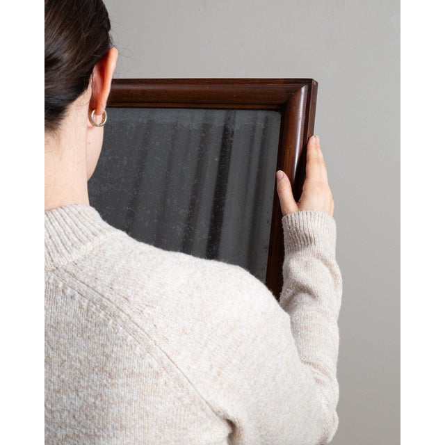 This piece presents as a cheval mirror, distinguished by dark mahogany frame, floor standing swing mirror. It was made in...