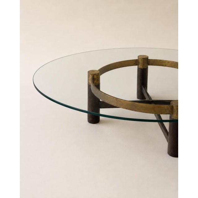 Vintage round glass coffee table with sculptural brass/ bronze-tone and dark wood base. Beautiful statement piece with a...