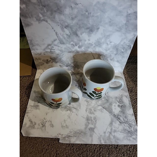 1970s Otagiri style Japanese stoneware mugs featuring a mod floral design. The eye-catching handpainted floral design are...