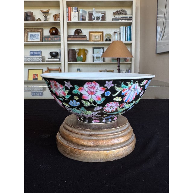 A striking set of four large Chinese porcelain bowls in the famille noire style, each featuring a deep black ground...