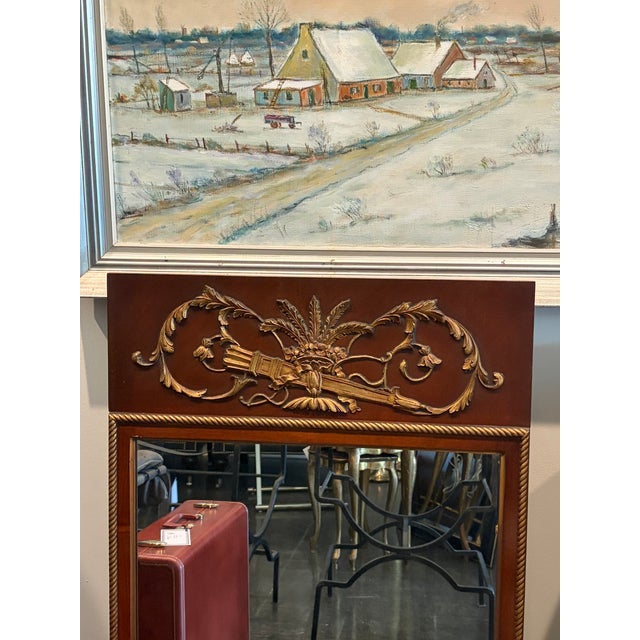 Elegant Empire-style wall mirror crafted in richly figured mahogany with a molded frame and an ornate brass ormolu crest...