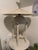 Iconic 1980s table lamp designed by Max Blumberg, featuring a sculptural urn-form body suspended within an architectural...