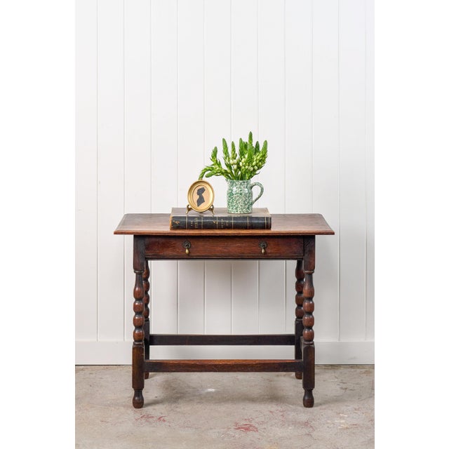 This 19th-century oak bobbin side table is crafted from dark oak wood. It has a clean rectangular top, single drawer with...