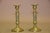 Pair of French bronze candlesticks dating to circa the 1910s. Each has a round stepped base, a column decorated with a...