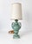 Small ceramic table lamp in with urn shaped body and scrolled handles with acanthus leaf details in celadon glaze. Lamp...