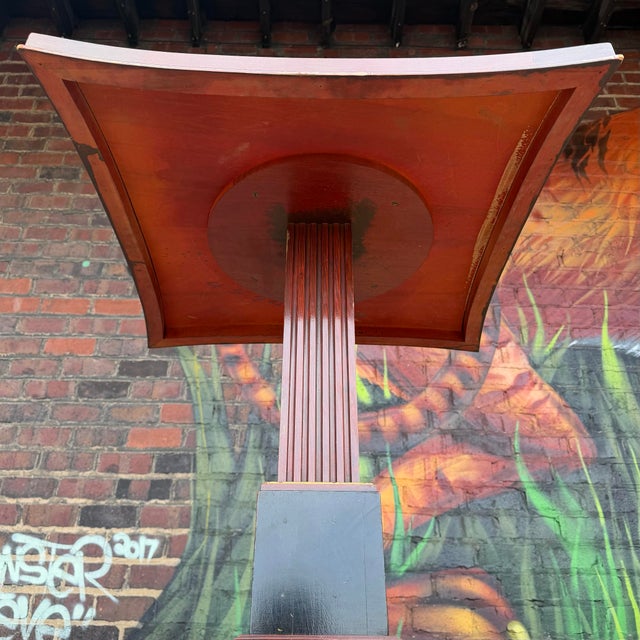 This antique table is an Art Deco pedestal table, likely dating from the 1920s to 1940s. The table top features a square...