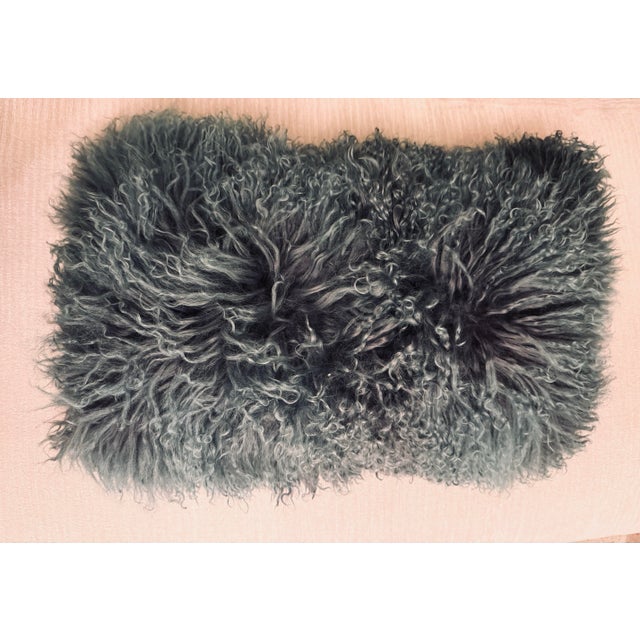 A plush, richly textured lumbar pillow in a beautiful teal blue-gray. The front is covered in long, curly fleece, while...