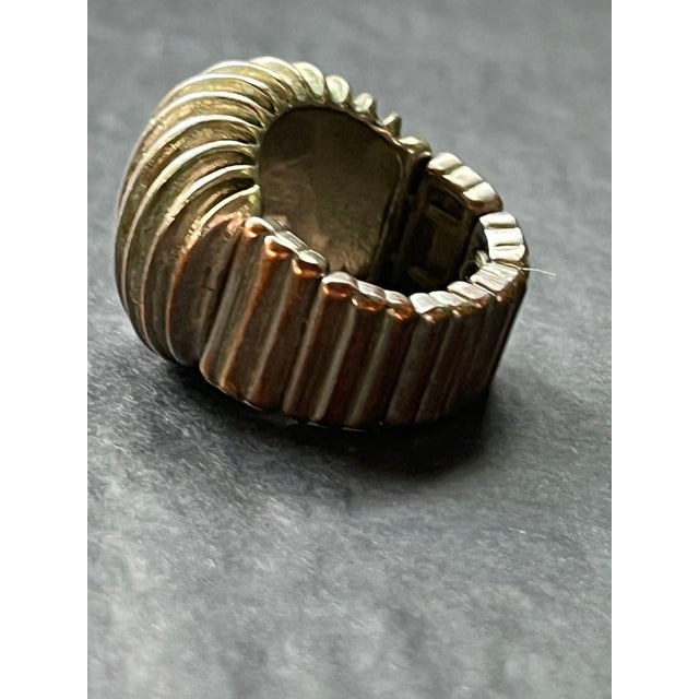 Vintage silver-tone fluted dome ring with an adjustable stretch band. The high-polish ridged surface gives it a...