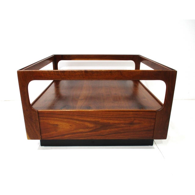 A dark well grained walnut and smoked glass square coffee table with lower shelve platform for books, magazines or...