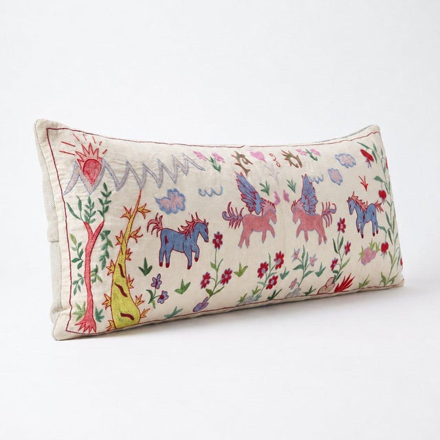 An extra-long lumbar pillow cover made from hand-embroidered Uzbek Suzani cotton — embroidered winged horses and flowering...