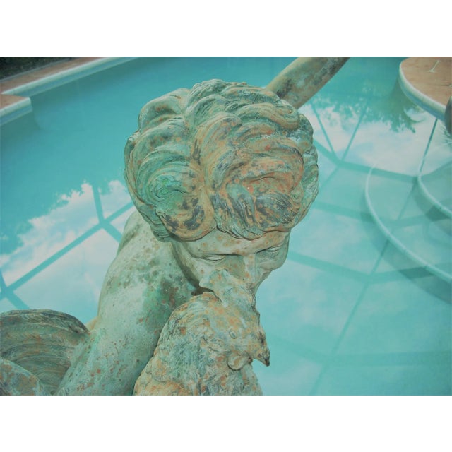 A classic cherub is waiting to romp in your vernal garden along with his young pet rooster; verdigris surface with...