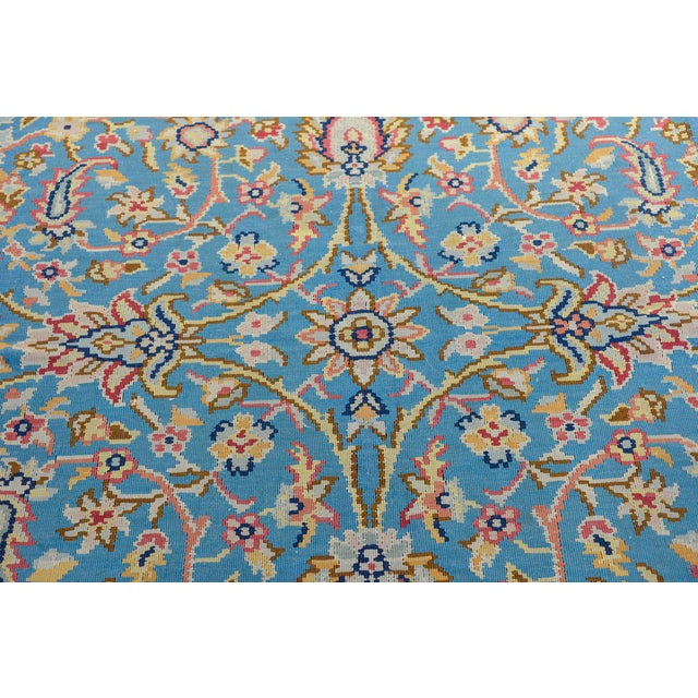 A sweet vintage Balkhan kilim rug with a mirrored floral pattern woven in pastel pinks, yellows, blues, and oranges,...