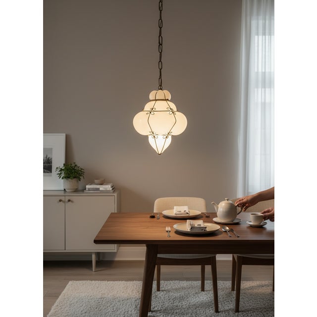 Elegant Italian pendant light featuring a hand-blown milky white Murano opaline glass shade encased within a decorative...