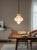 Elegant Italian pendant light featuring a hand-blown milky white Murano opaline glass shade encased within a decorative...
