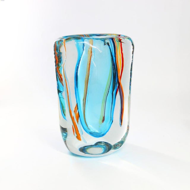 This Murano glass vase is crafted by hand using the blowing technique, it features vibrant colors and intricate details...