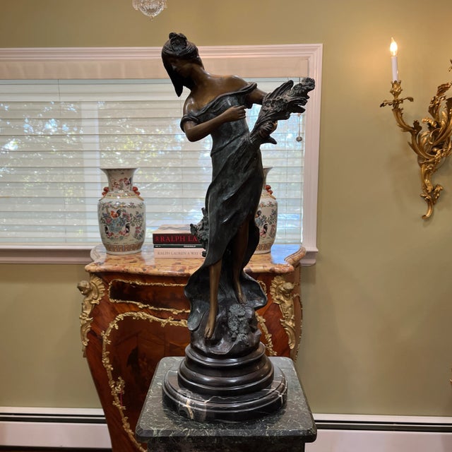 A timeless decor piece that adds elegance and romance to any indoor space. Antique reproduction bronze statue with black...