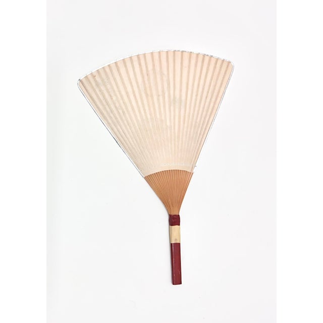 Decorative mid-century Japanese rigid fan featuring fruit motif and calligraphic inscription. An authentic example of...