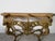 A stunning vintage Hollywood Regency style console table base featuring elaborate carved wood details with a rich gilt...