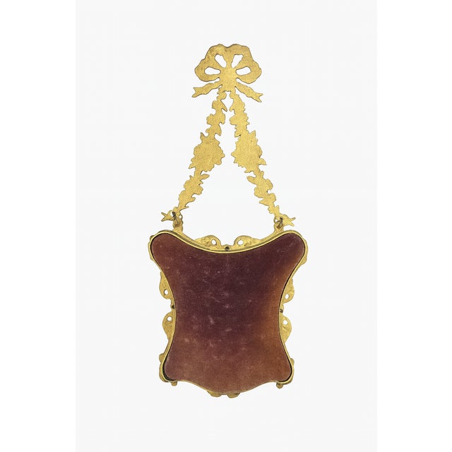 This elegant pair of brass picture frames features ornate Rococo-style scrollwork, floral details, and delicate ribbon...