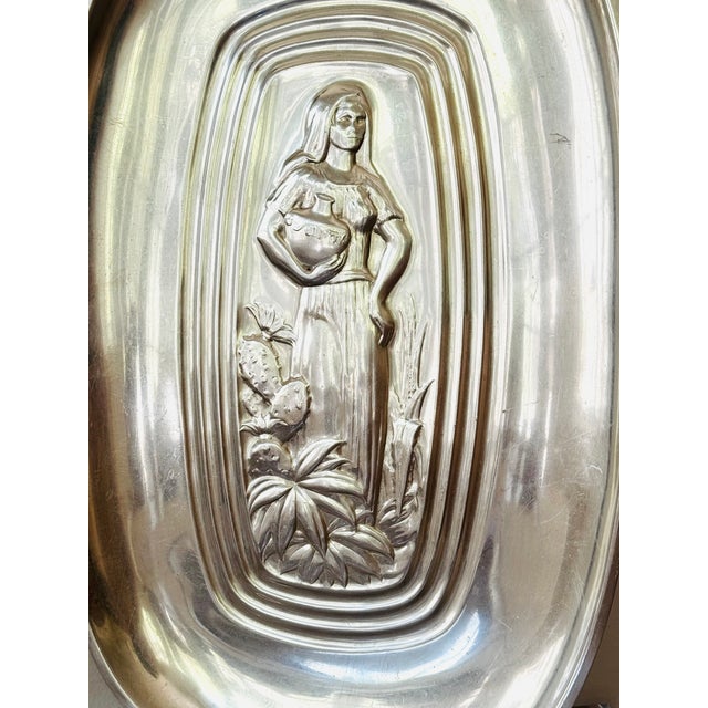 A silver plated tray with image of woman carrying a jug. The Tropical line of International Silver Company from the...
