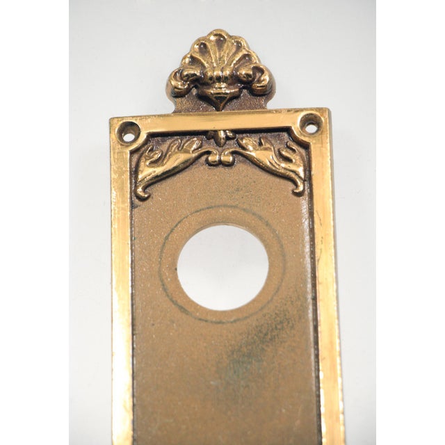 Reclaimed Plaza Hotel door plate with a lock and door knob inserts. It is embellished with a classic shell inspired...