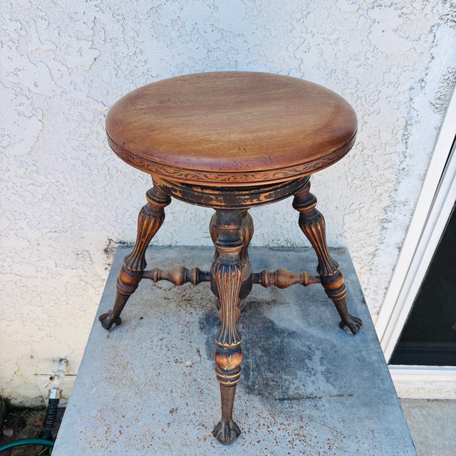 This is an old antique piano stool from the early 20th Century. Made from oak, it has decoratively turned wood legs,...