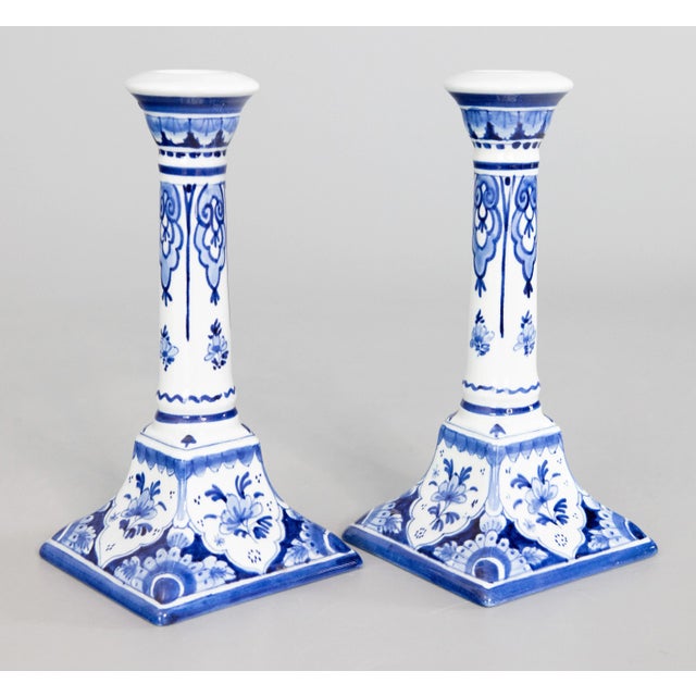 A lovely pair of Mid-Century Dutch Delft faience candlesticks. Maker's mark on reverse. These fine candlesticks are hand...