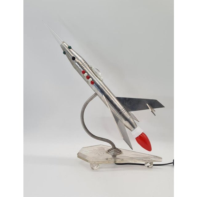 An original, handcrafted table lamp shaped like a rocket or a futuristic aircraft, designed in a Space Age aesthetic...