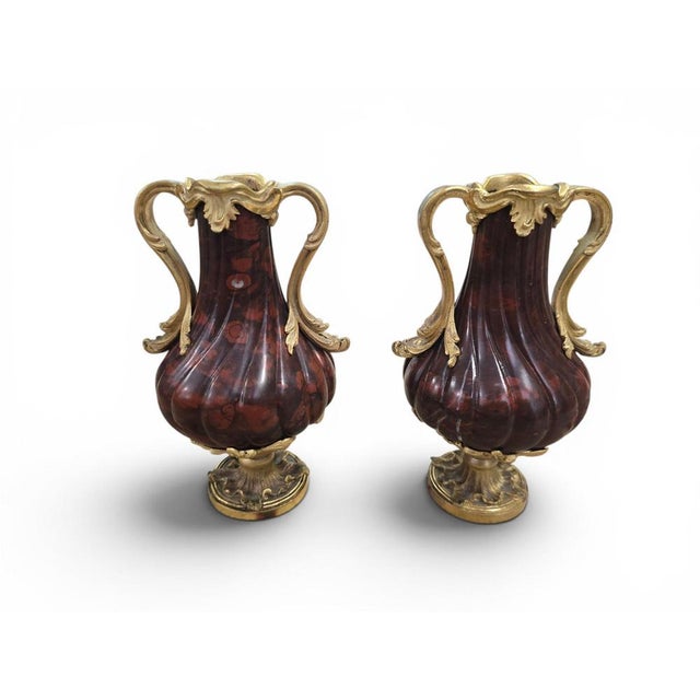 Elegant pair of French decorative vases crafted from turned red marble and enriched with finely chased gilt bronze mounts....