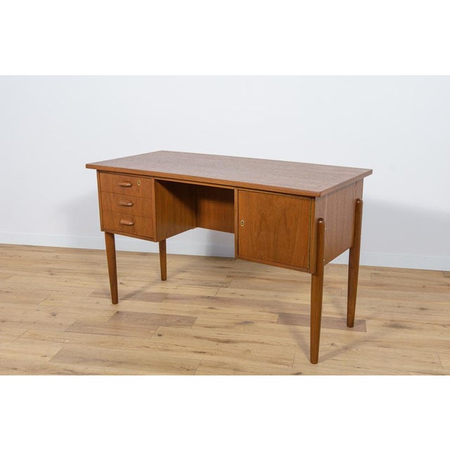 This desk was made in Denmark in the 1960s. It was made of teak wood with contoured handles. It consists of two modules,...