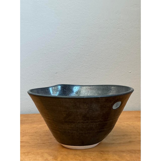 This exquisite studio pottery bowl is a masterclass in mid-century artisanal craftsmanship, blending organic form with a...