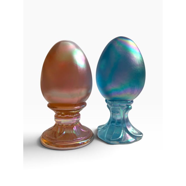 Beautiful vintage pair of iridescent art glass eggs in complementary pink/amber and aqua blue tones. Each egg features a...