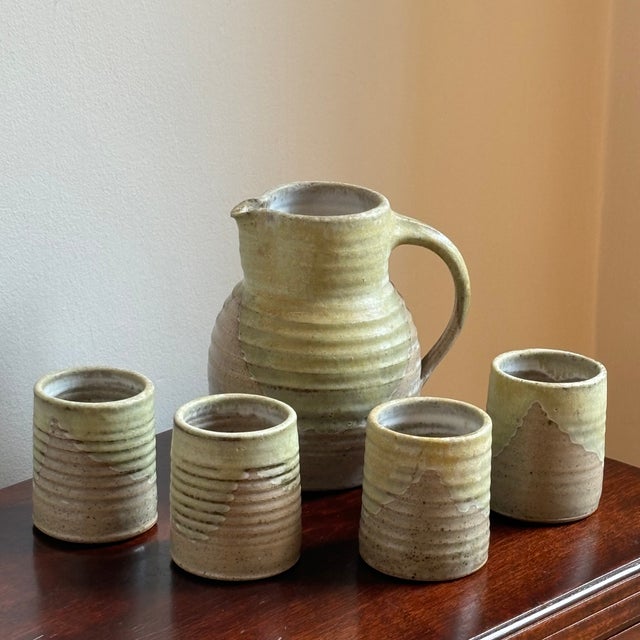 Offering a lovely vintage stoneware pitcher and four matching tumblers. This beautiful hand-thrown artisanal set features...