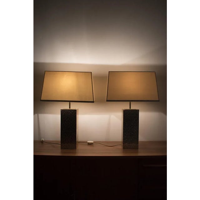 A pair of hollywood regency style table lamps by vereinigte werkstätten münchen. These duotone (chrome/brass) lamps have...